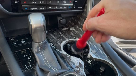 Detailer restoring a cloudy vehicle headlight